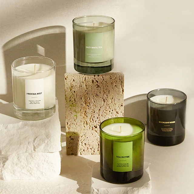 Clear, green and dark round glass candle jars in a styled group