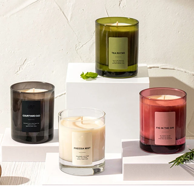 Green, smoke, pink and clear round glass candle jars in a display