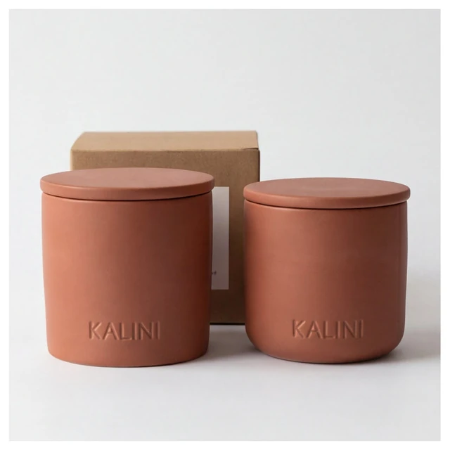 Terracotta-color round ceramic candle jars with lids and a box