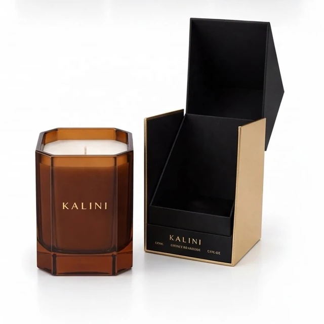 Amber faceted glass candle jar beside an open black and gold presentation box