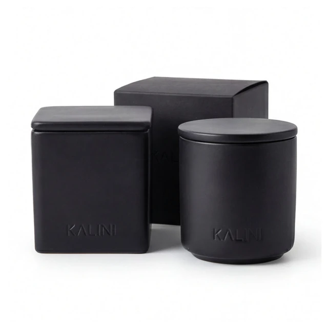 Black square and round ceramic candle jars with lids and a black box