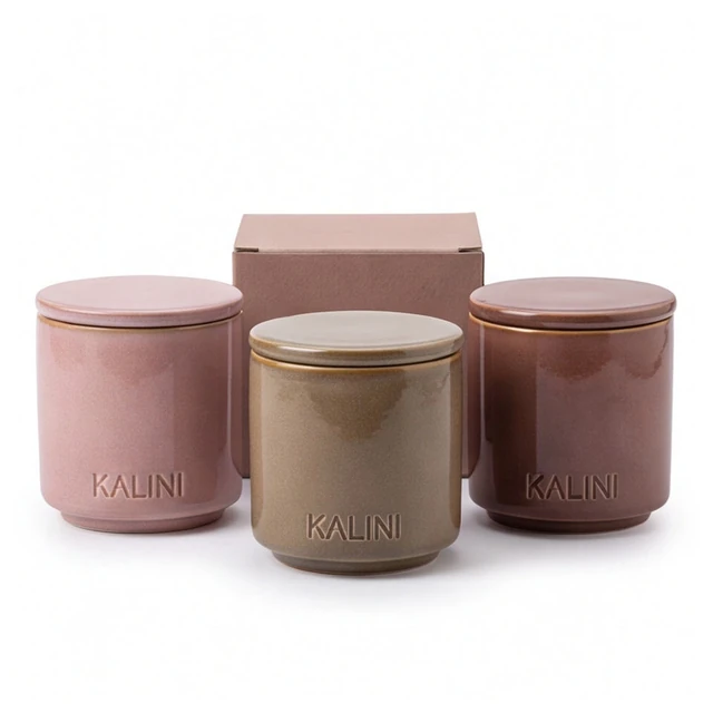 Pink and brown round ceramic candle jars with lids and a pink box