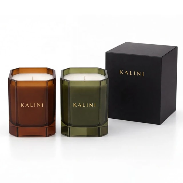 Amber and olive faceted glass candle jars beside a closed black KALINI box
